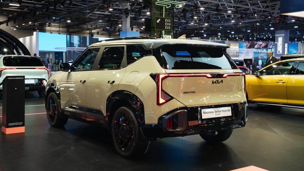 Kia Seltos hybride beige vu de trois quarts arrière sur le stand Kia