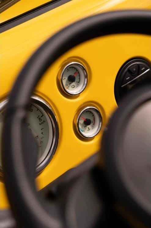 Planche de bord jaune de la Moke électrique avec compteurs ronds