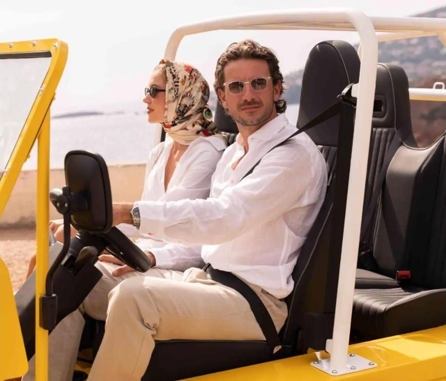 Habitacle de la Moke électrique jaune avec conducteur, passagère et arceau blanc