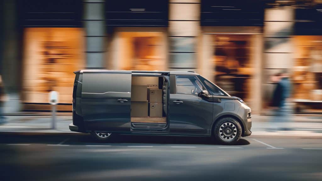 Renault Trafic Van E-Tech electric de profil, porte latérale ouverte sur des colis